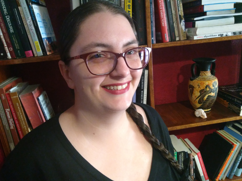 Morgan standing in front of a bookshelf