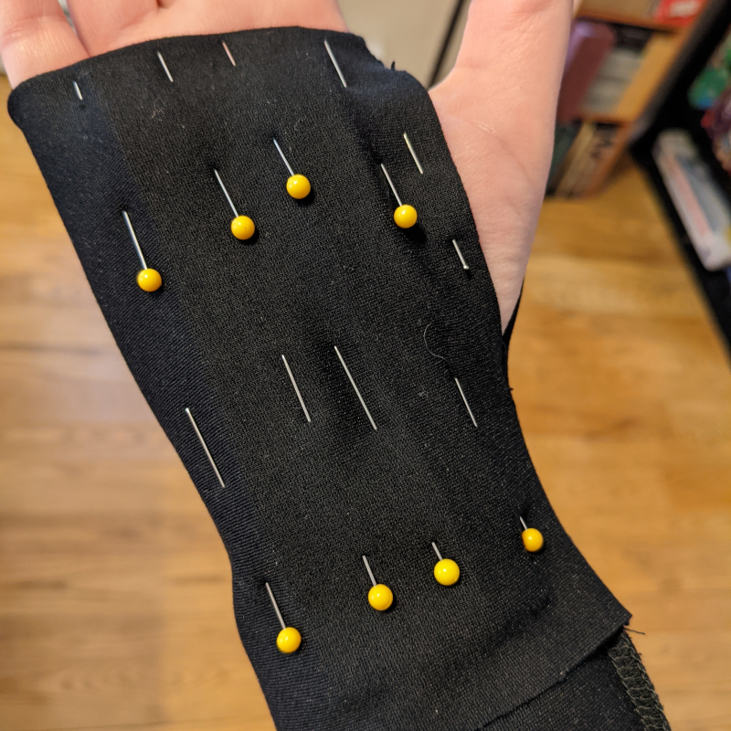 The glove on my hand with pins on the sides of the padding strips holding them in place