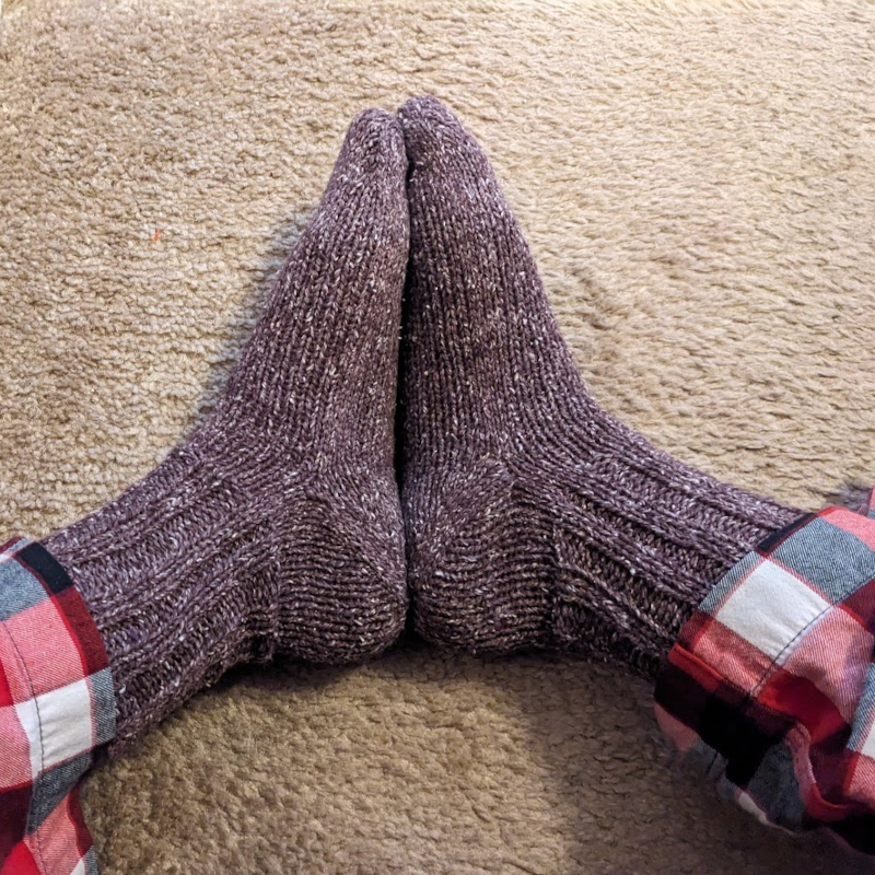 My feet wearing a pair of cuff-down afterthought heel handmade socks