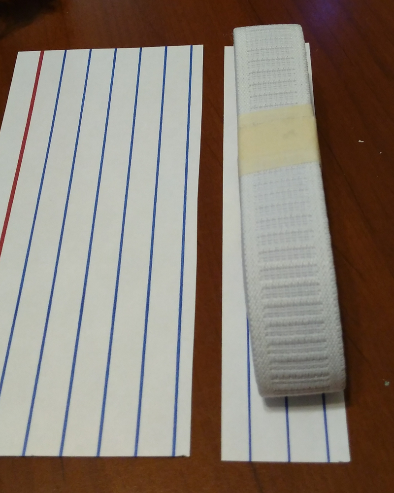Elastic on top of a cut index card to demonstrate a hem template
