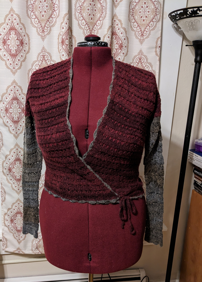 A wrap sweater in a burgundy and gray cashmere/wool blend on a dress form